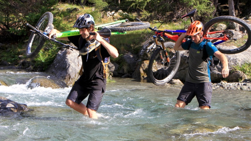 Mountain bikers cross a river, Lake Wanaka NZ